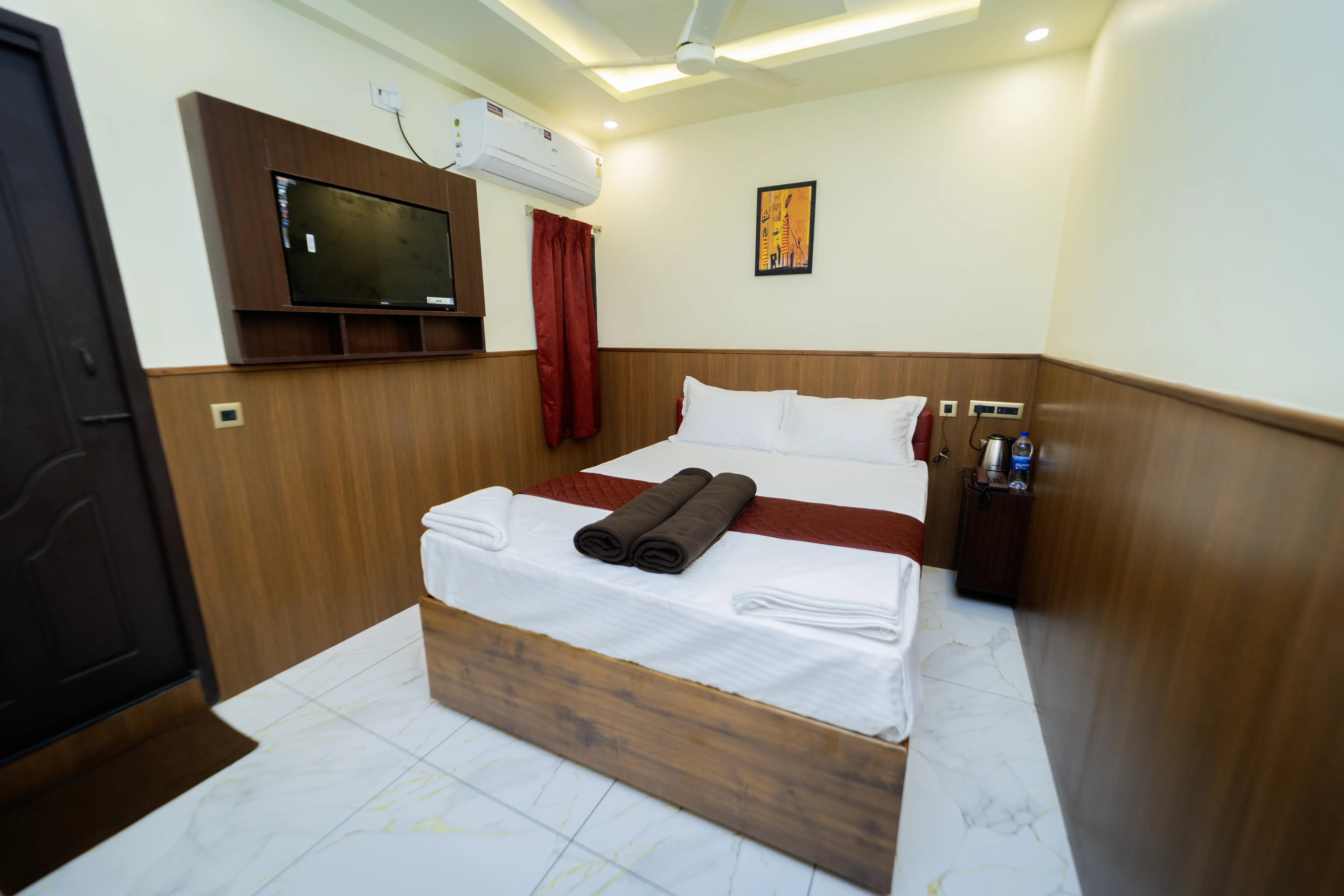 Deluxe Room with double bed, wall-mounted TV and air conditioner