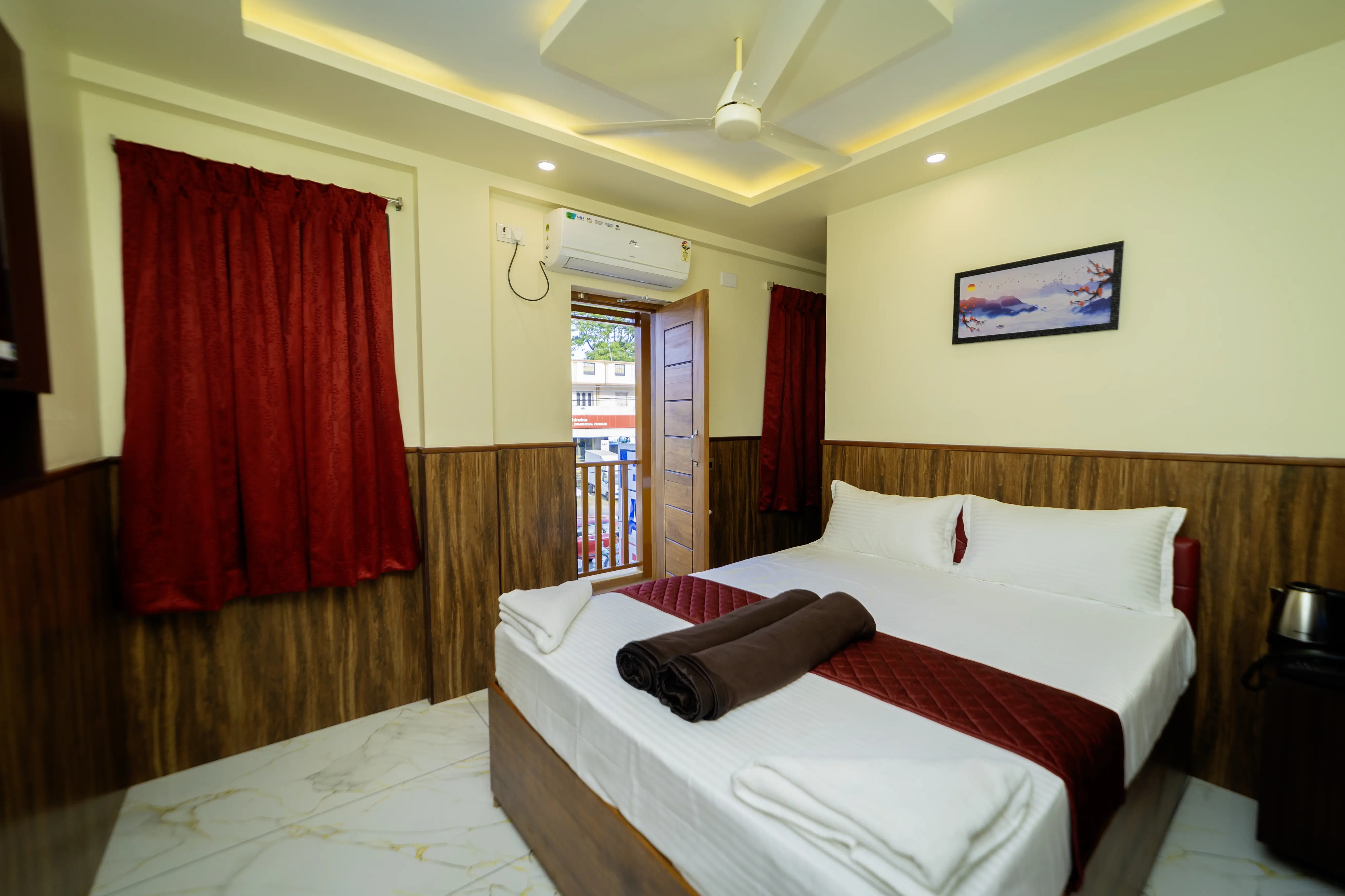 Guest room with double bed, red curtains and open balcony door