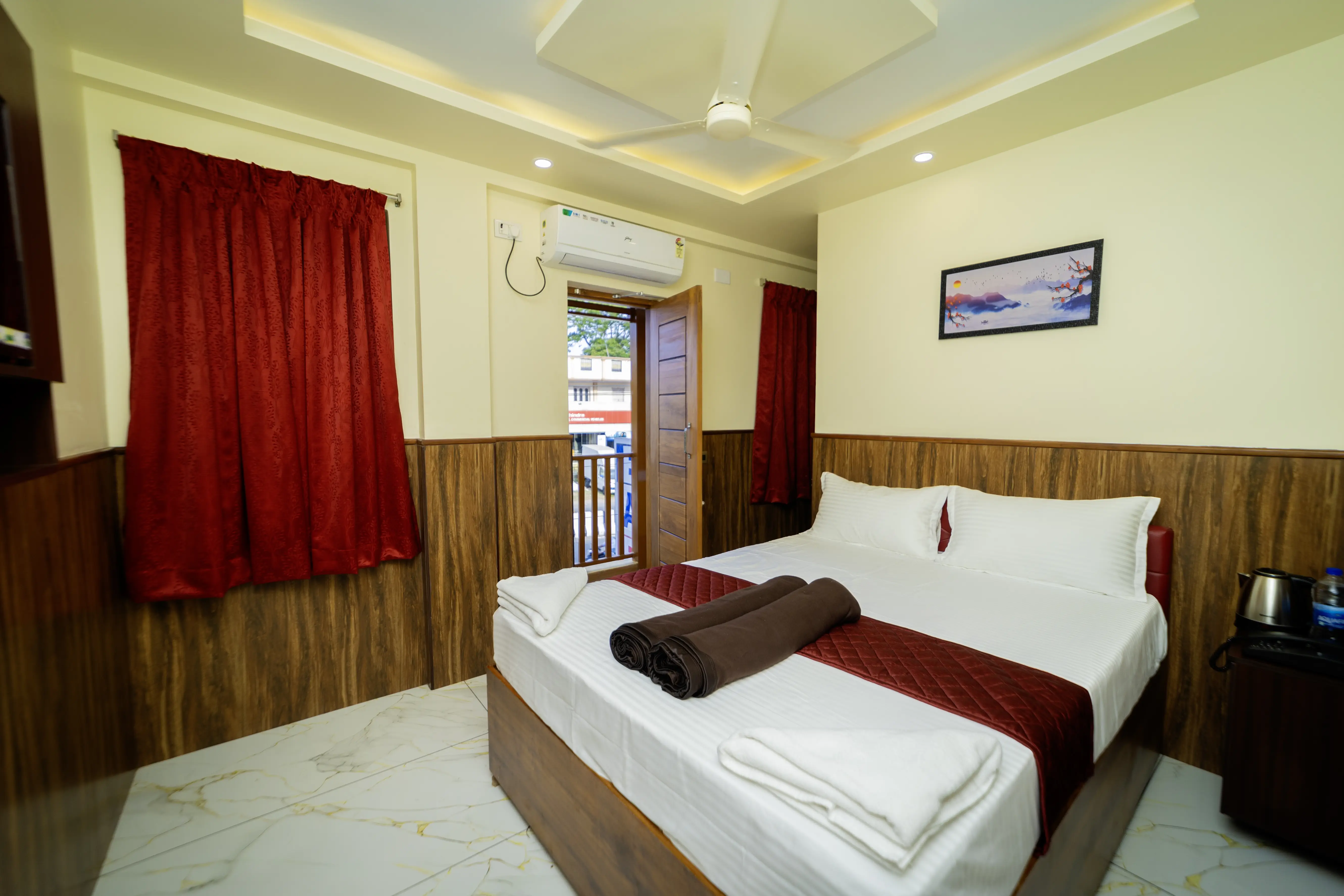 Double Room with Balcony showing bed, red curtains and balcony door