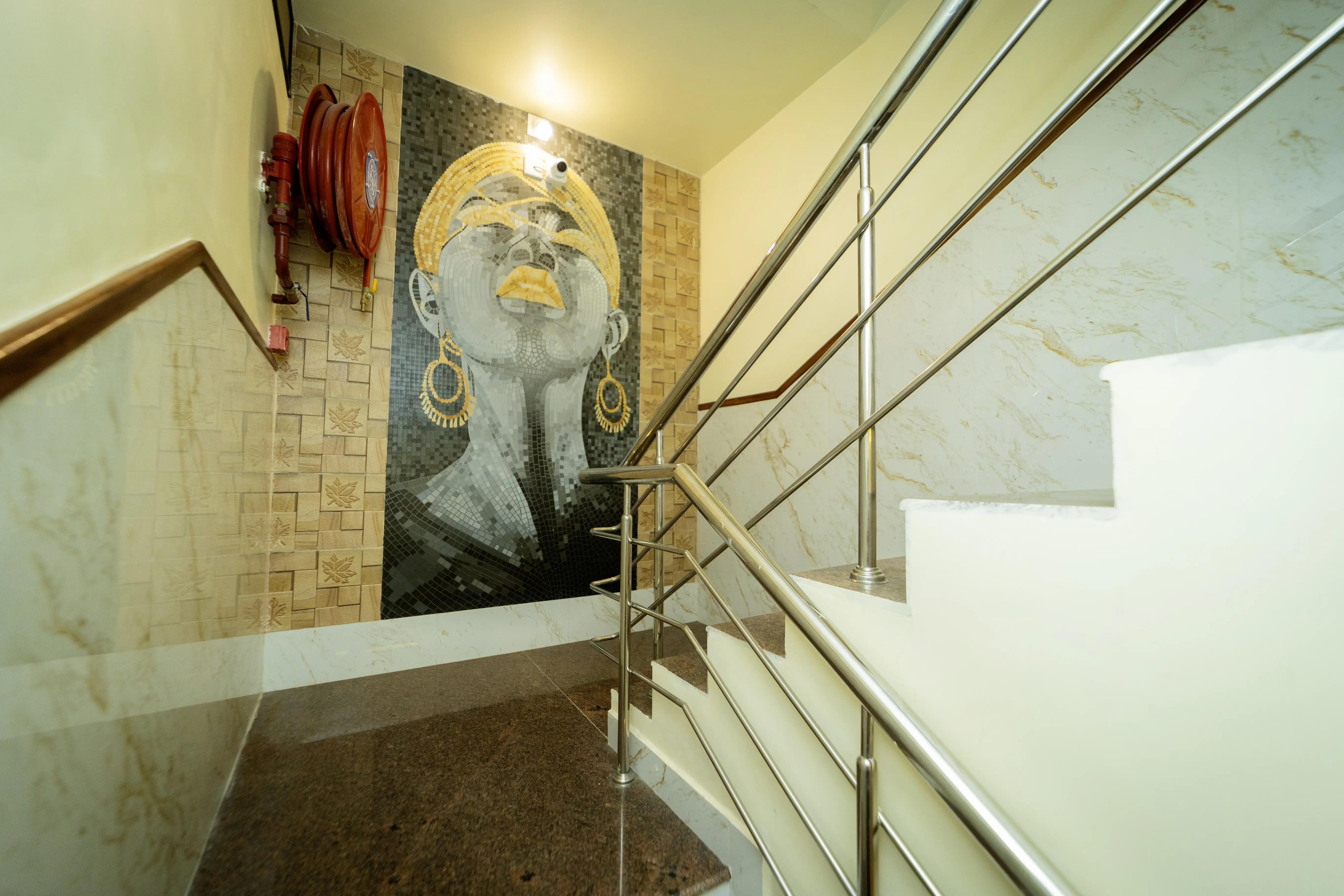 Staircase with steel railings and a mosaic portrait wall